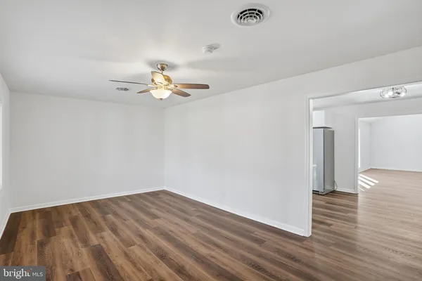 a view of a room with wooden floor and a ceiling fan