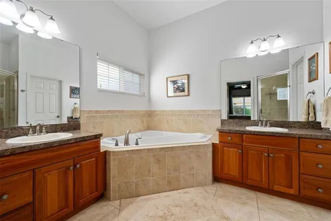 a spacious bathroom with a sink double vanity granite tub and a mirror