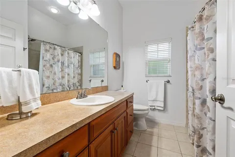 a bathroom with a granite countertop sink mirror vanity and toilet