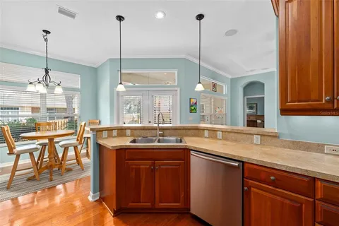 a kitchen with kitchen island granite countertop a sink a counter top space and living room view