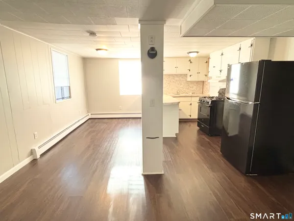 a view of a kitchen with wooden floor and stainless steel appliances