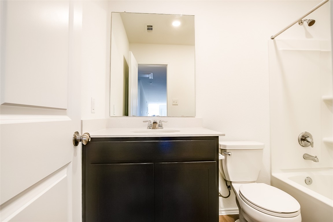 1133 Largemouth Road Bastrop, TX 78602 - Photo 13 of 16 a bathroom with a sink a toilet and a mirror