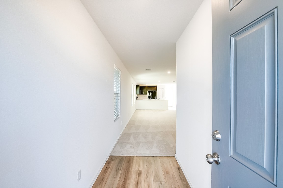 1133 Largemouth Road Bastrop, TX 78602 - Photo 4 of 16 a view of a hallway with wooden floor and a bathroom