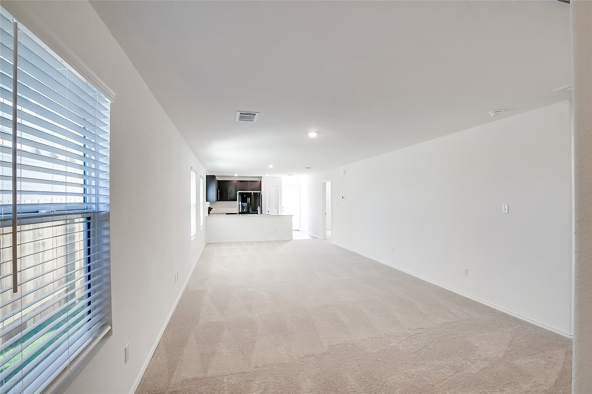 1133 Largemouth Road Bastrop, TX 78602 - Photo 5 of 16 a view of a big room with wooden floor and a ceiling fan