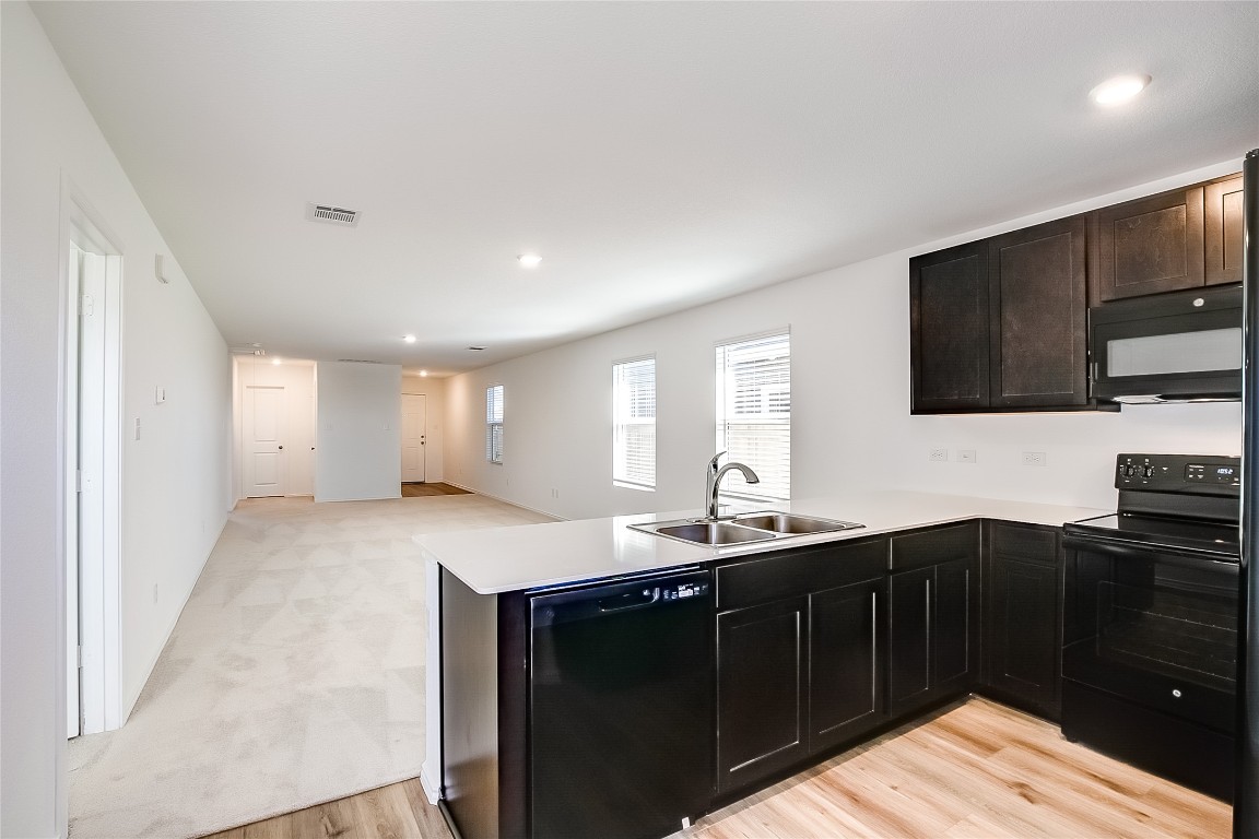1133 Largemouth Road Bastrop, TX 78602 - Photo 8 of 16 a kitchen with a sink and a stove top oven with wooden floor