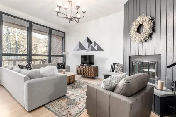 a living room with furniture a fireplace and a large window