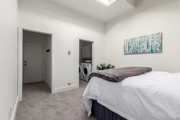 a spacious bedroom with a bed and a potted plant