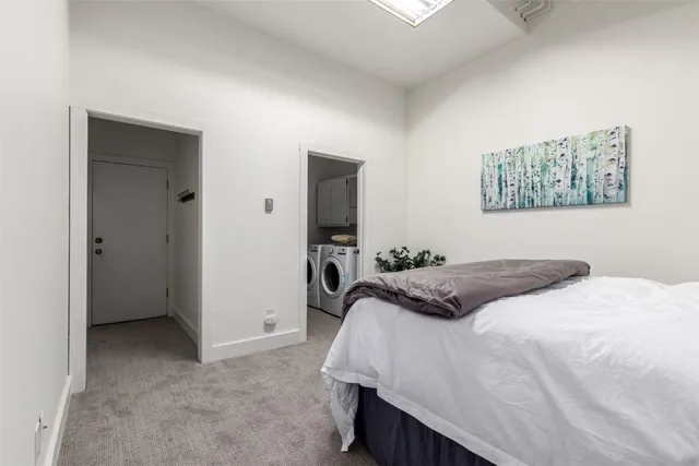 a spacious bedroom with a bed and a potted plant