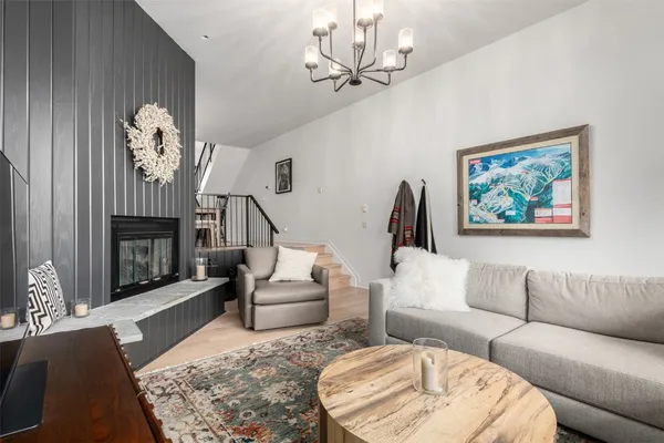 a living room with furniture a chandelier and a fireplace