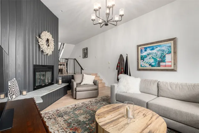a living room with furniture a chandelier and a fireplace