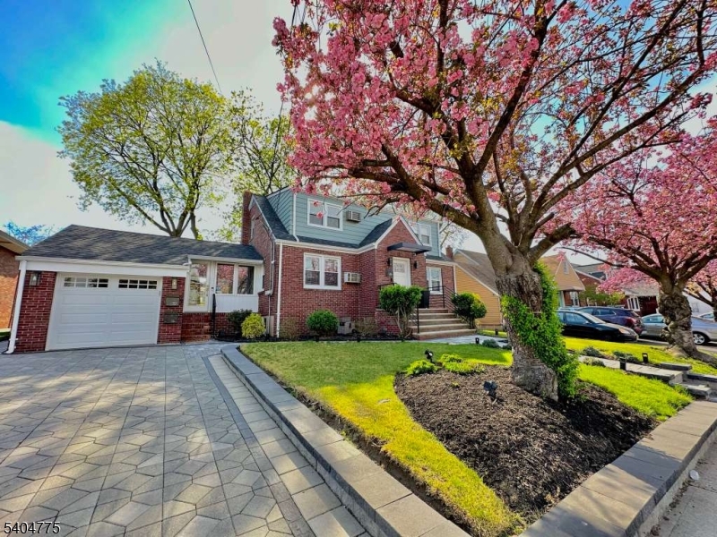 a front view of a house with a garden and trees