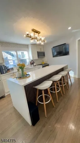 a dinning room with wooden floor and chandelier