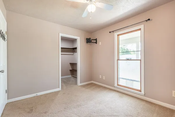 an empty room with windows and closet