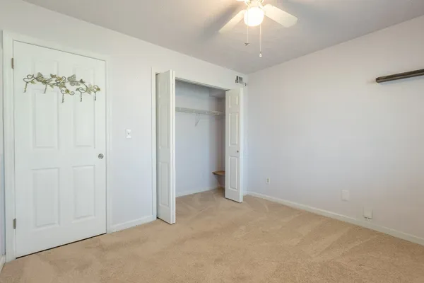 an empty room with a chandelier fan