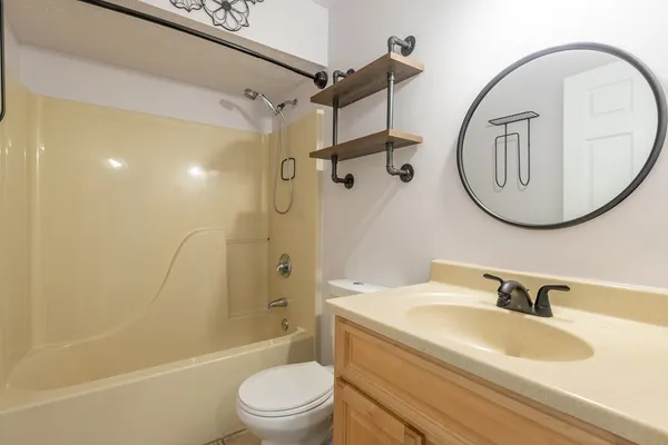 a bathroom with a sink a toilet and a mirror