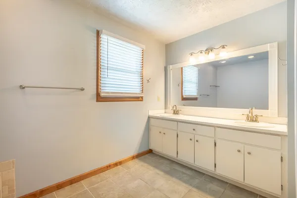 a bathroom with a double vanity sink and a mirror