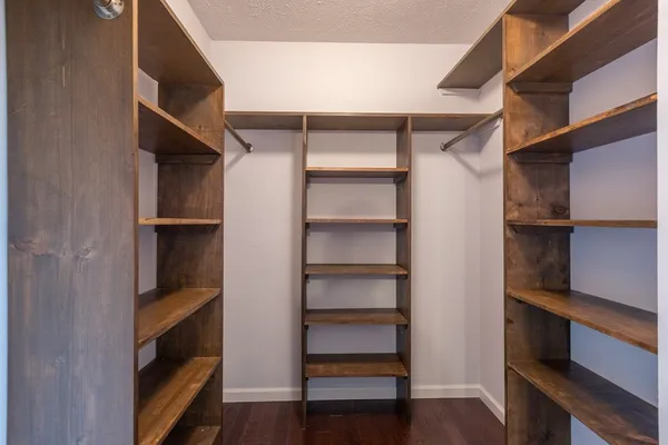 a view of walk in closet with empty racks