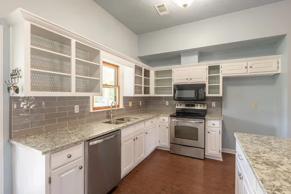 a kitchen with stainless steel appliances granite countertop a stove and a sink