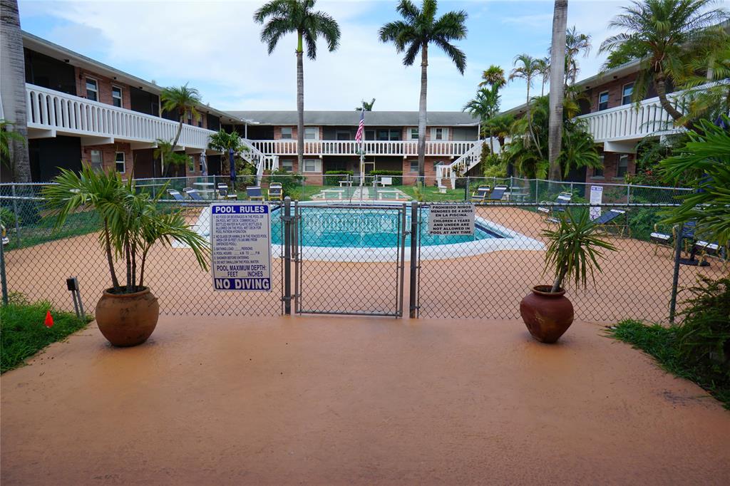 160 Northeast 8th Avenue, Unit 25B Hallandale Beach, FL 33009 - Photo 2 of 35 a view of a swimming pool with a seating area and potted plants
