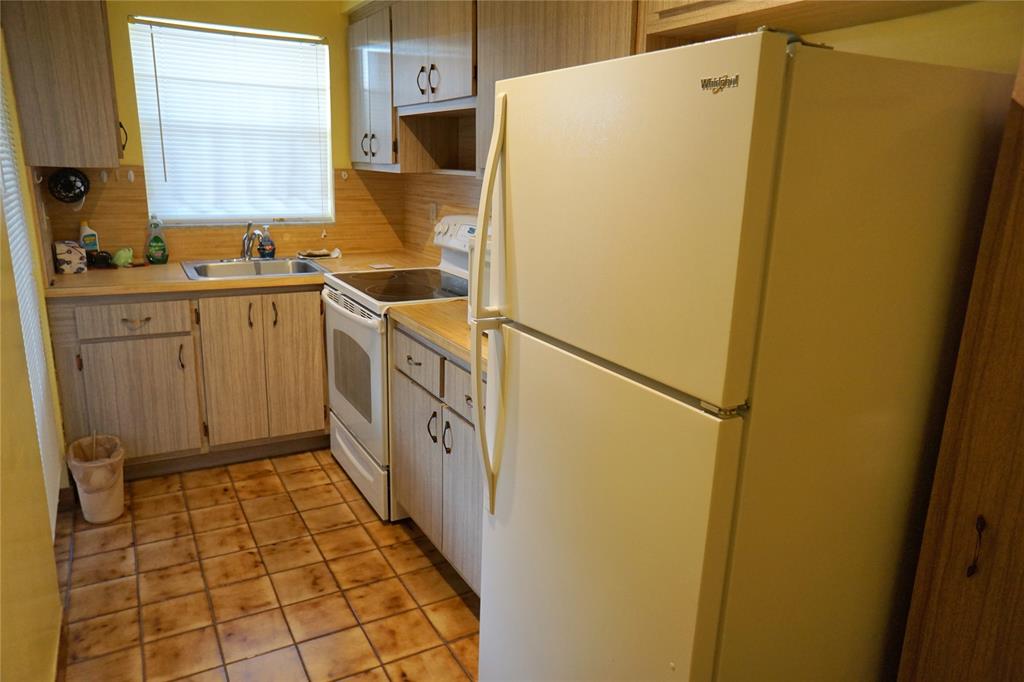 160 Northeast 8th Avenue, Unit 25B Hallandale Beach, FL 33009 - Photo 22 of 35 a kitchen with sink a refrigerator and a stove