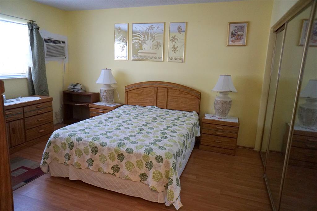 160 Northeast 8th Avenue, Unit 25B Hallandale Beach, FL 33009 - Photo 23 of 35 a bedroom with a bed and a table in it