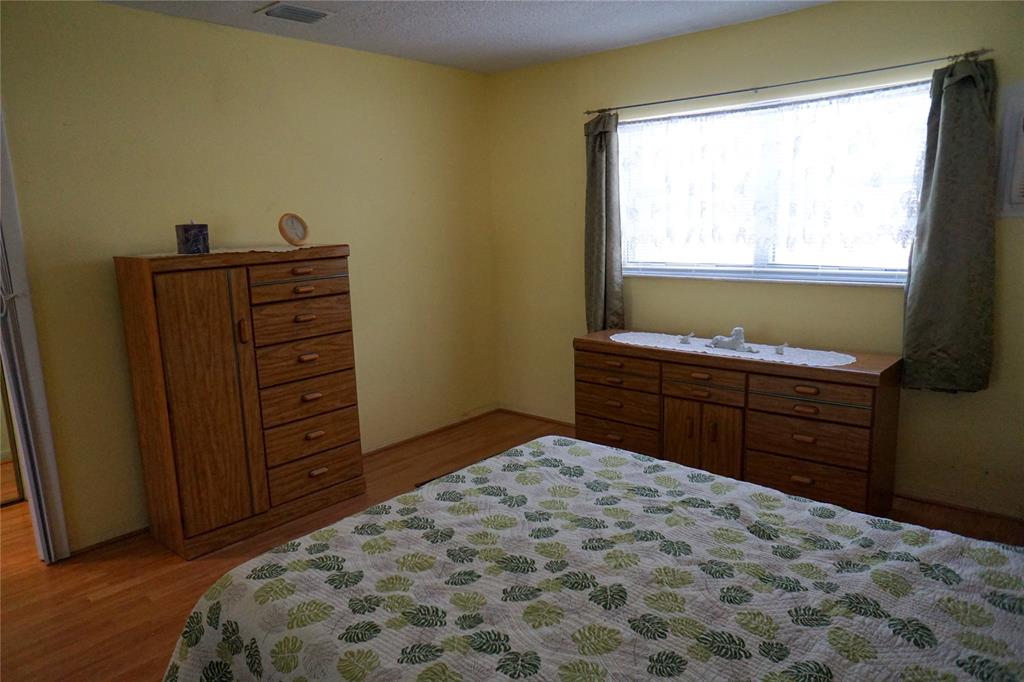 160 Northeast 8th Avenue, Unit 25B Hallandale Beach, FL 33009 - Photo 24 of 35 a bedroom with a bed and a dresser