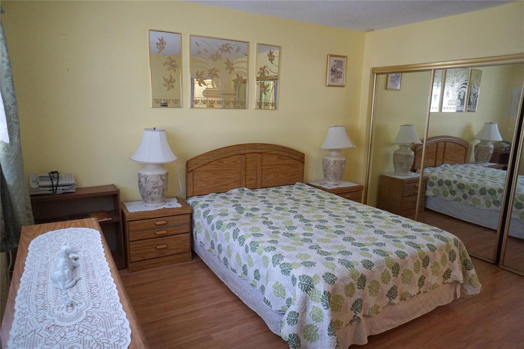 160 Northeast 8th Avenue, Unit 25B Hallandale Beach, FL 33009 - Photo 25 of 35 a bedroom with a bed and a mirror