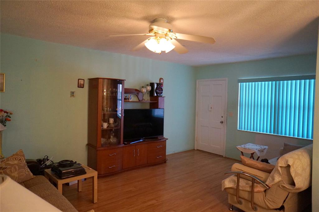 160 Northeast 8th Avenue, Unit 25B Hallandale Beach, FL 33009 - Photo 34 of 35 a living room with furniture and a window