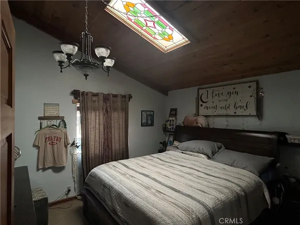 a bedroom with a bed and a chandelier