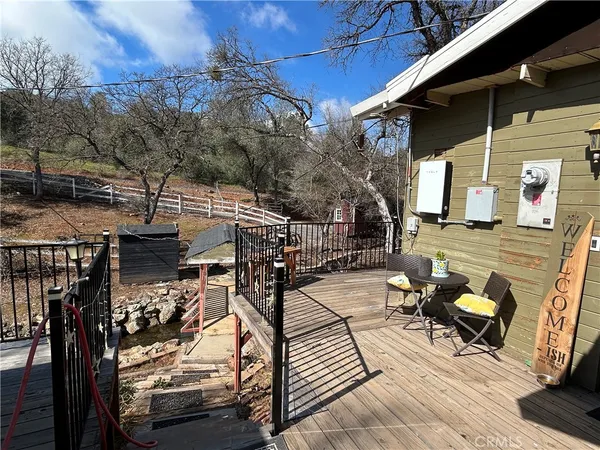 a view of a patio with table and chairs with wooden floor and fence