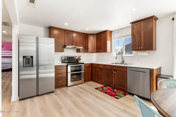 a kitchen with stainless steel appliances kitchen island granite countertop a refrigerator stove microwave and white cabinets