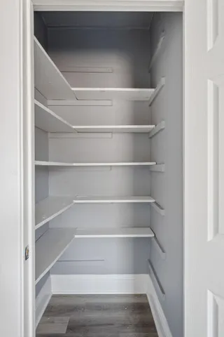 a view of walk in closet with empty racks