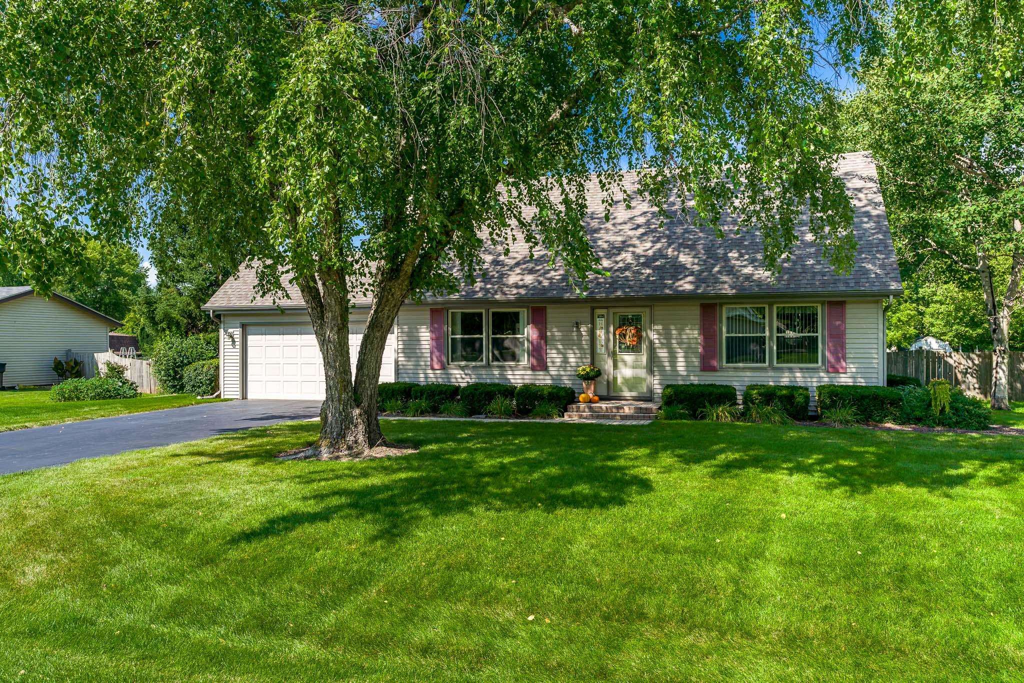 11748 Cedarbrook Road Roscoe, IL 61073 - Photo 1 of 50 a front view of a house with a garden and trees
