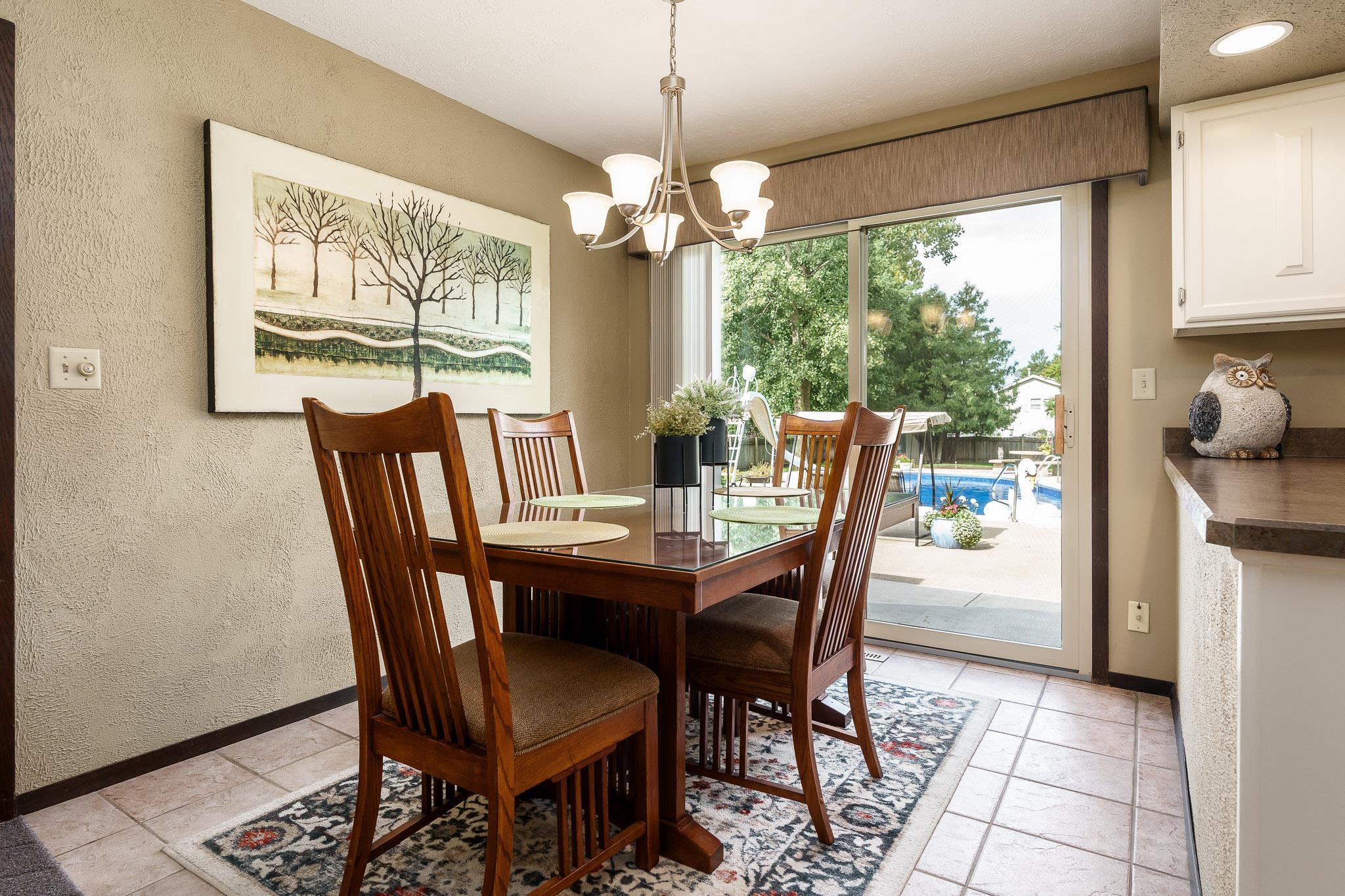 11748 Cedarbrook Road Roscoe, IL 61073 - Photo 11 of 50 a dining room with furniture a chandelier and wooden floor