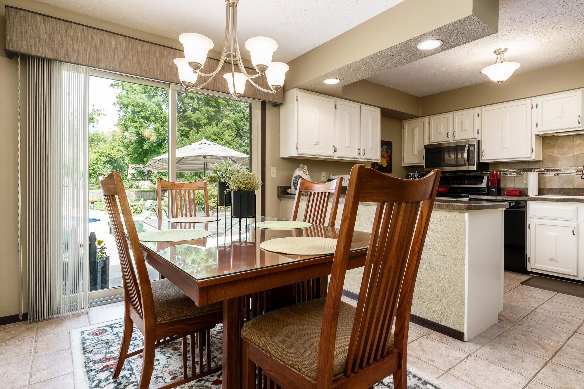 11748 Cedarbrook Road Roscoe, IL 61073 - Photo 12 of 50 a dining room with furniture a large window and chandelier