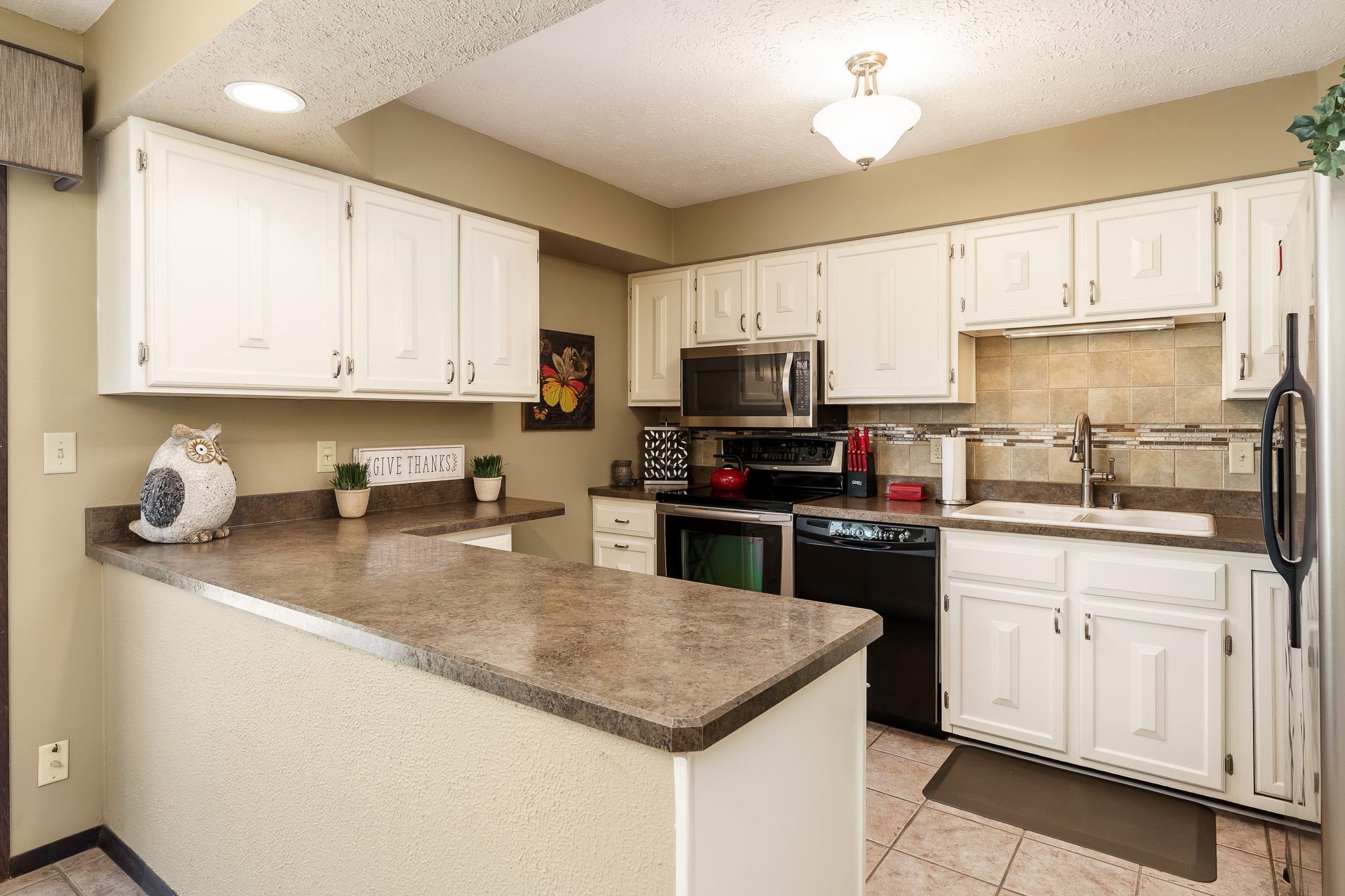 11748 Cedarbrook Road Roscoe, IL 61073 - Photo 13 of 50 a kitchen with sink a microwave and cabinets