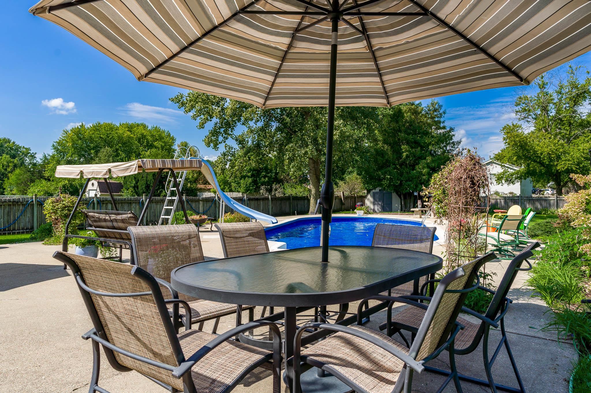 11748 Cedarbrook Road Roscoe, IL 61073 - Photo 49 of 50 a view of patio with table and chairs under an umbrella