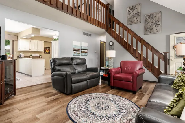 a dining room with furniture a chandelier and wooden floor