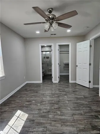 a view of an empty room with closet and a window