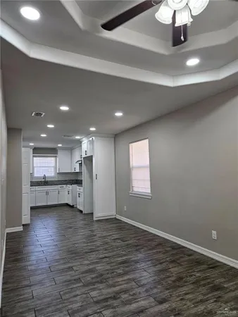 a view of a kitchen with a sink and dishwasher a refrigerator with wooden floor