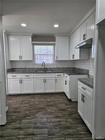 a kitchen with stainless steel appliances granite countertop a sink a stove a refrigerator and cabinets