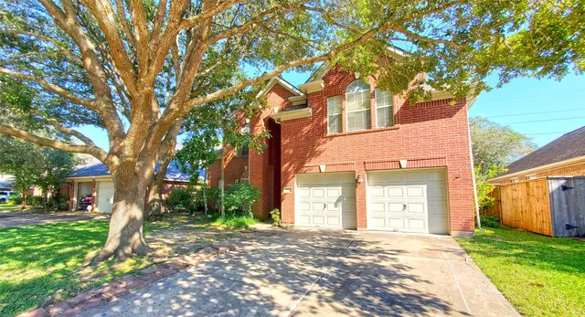 a front view of a house with a garden and trees