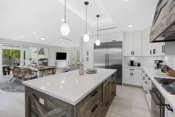 a kitchen with a white center island a sink stainless steel appliances and cabinets