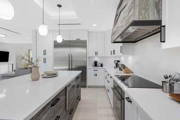 a kitchen with stainless steel appliances granite countertop a sink a stove and a wooden floors