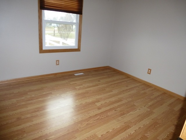 6 Crofton Road Oswego, IL 60543 - Photo 16 of 24 an empty room with wooden floor and windows
