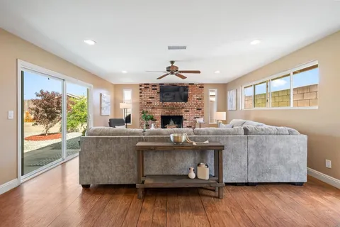 a living room with furniture a fireplace and wooden floor