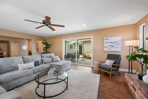 a living room with furniture and a ceiling fan