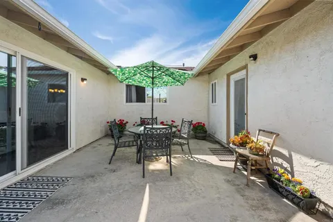 a view of a patio with table and chairs and potted plants