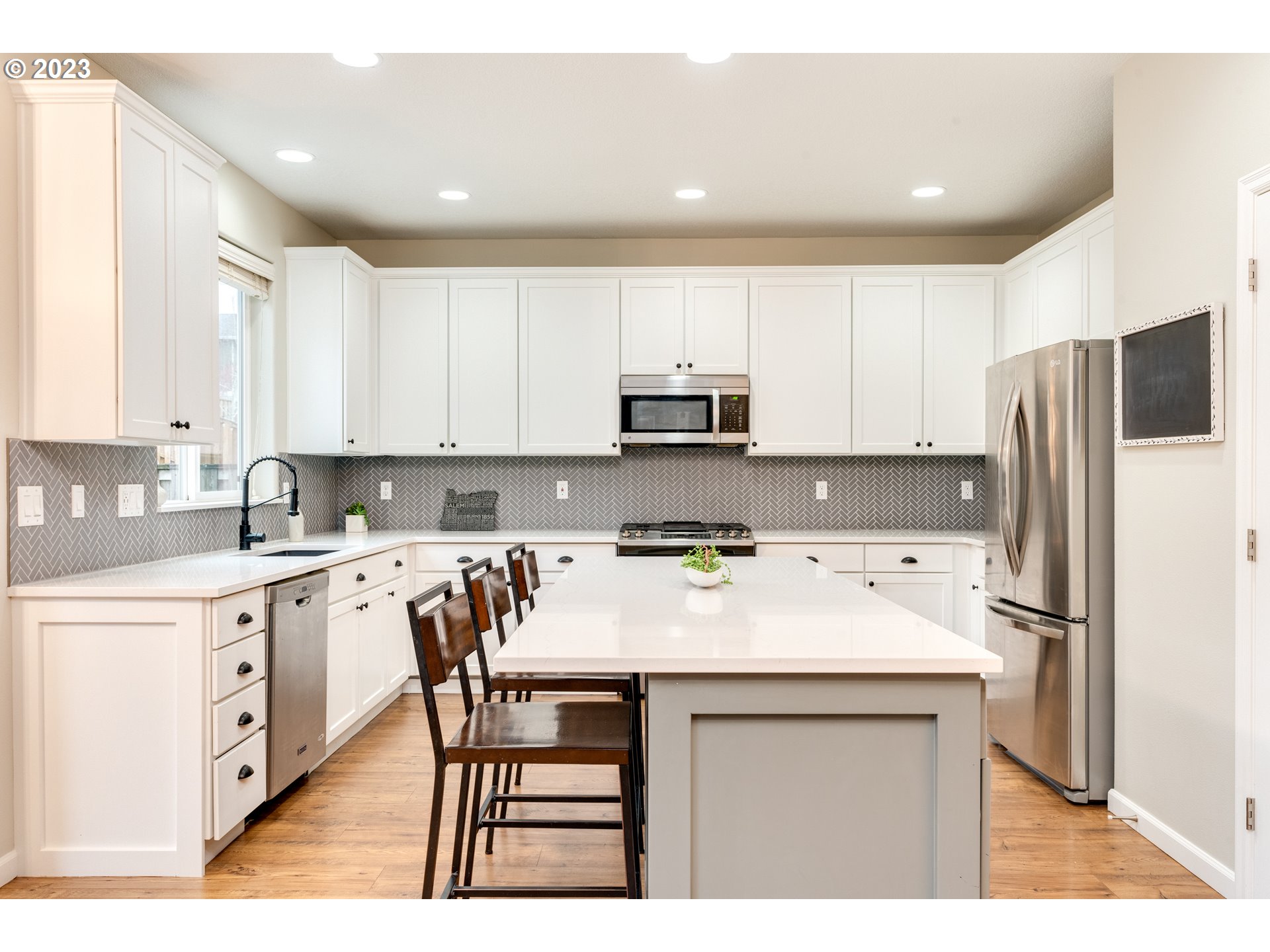 16270 Southeast Jasper Drive Damascus, OR 97089 - Photo 13 of 32 a kitchen with a sink a stove a refrigerator and white cabinets