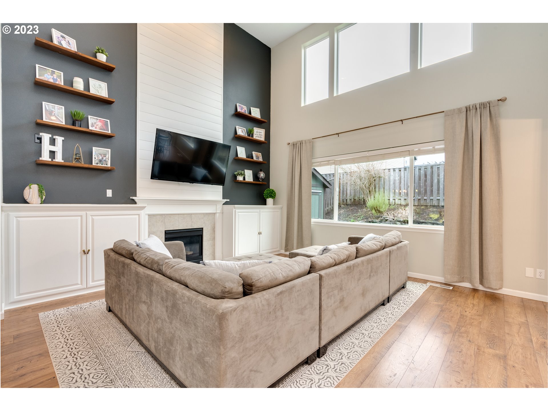 16270 Southeast Jasper Drive Damascus, OR 97089 - Photo 9 of 32 a living room with furniture a flat screen tv and a fireplace